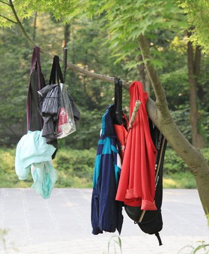 资料图片:游客把衣服、袋子等物品悬挂在南京中山风景区一棵小树上。