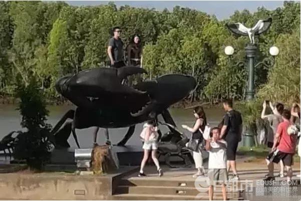 中国游客泰国爬雕塑拍照